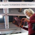 Na 56.medjunarodnom sajmu knjiga u Beogradu, Milica Stojković razgleda svoju knjigu pred štandom RTSa